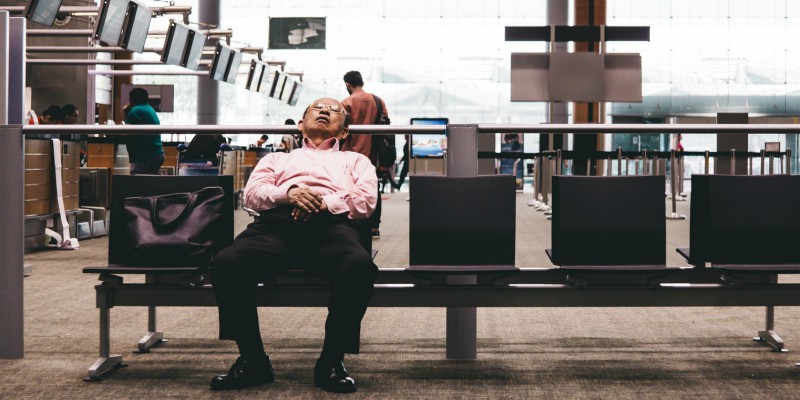 Man sleeps on a seat in an airport terminal 