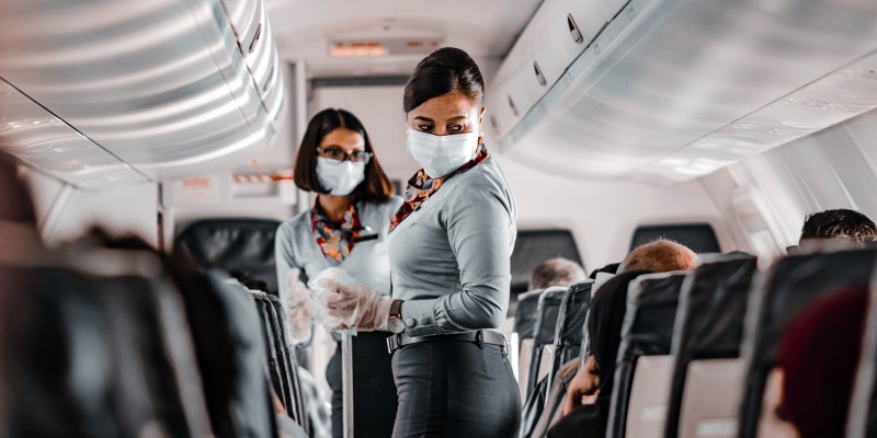 Cabin crew wear masks on an aeroplane