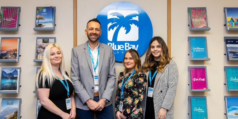 Blue Bay employees pose under the sign